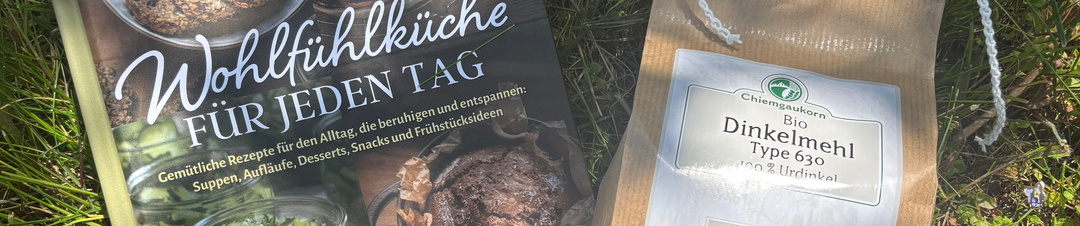 Ein offenes Buch und Gemüse liegen auf einer grauen Fläche