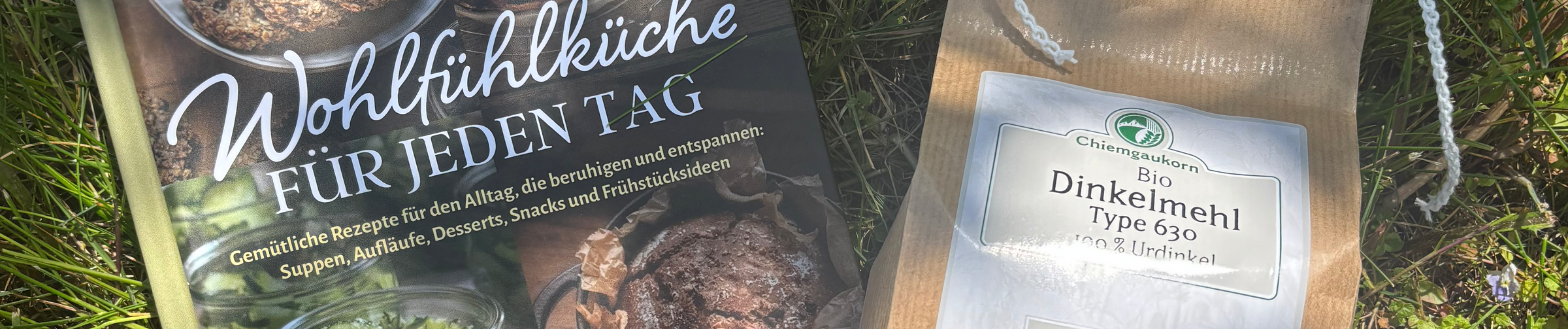 Ein offenes Buch und Gemüse liegen auf einer grauen Fläche