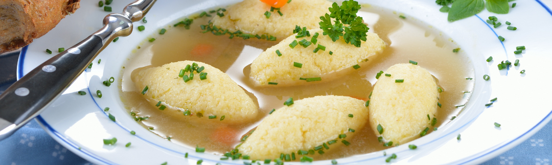 Eine Suppenschüssel mit einer Brühe und Klößen